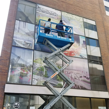 window decals being installed via workers on a crane