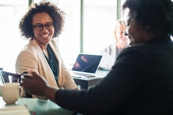 two women looking at a phone and smiling