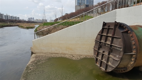 large diameter drain pipe next to a stream